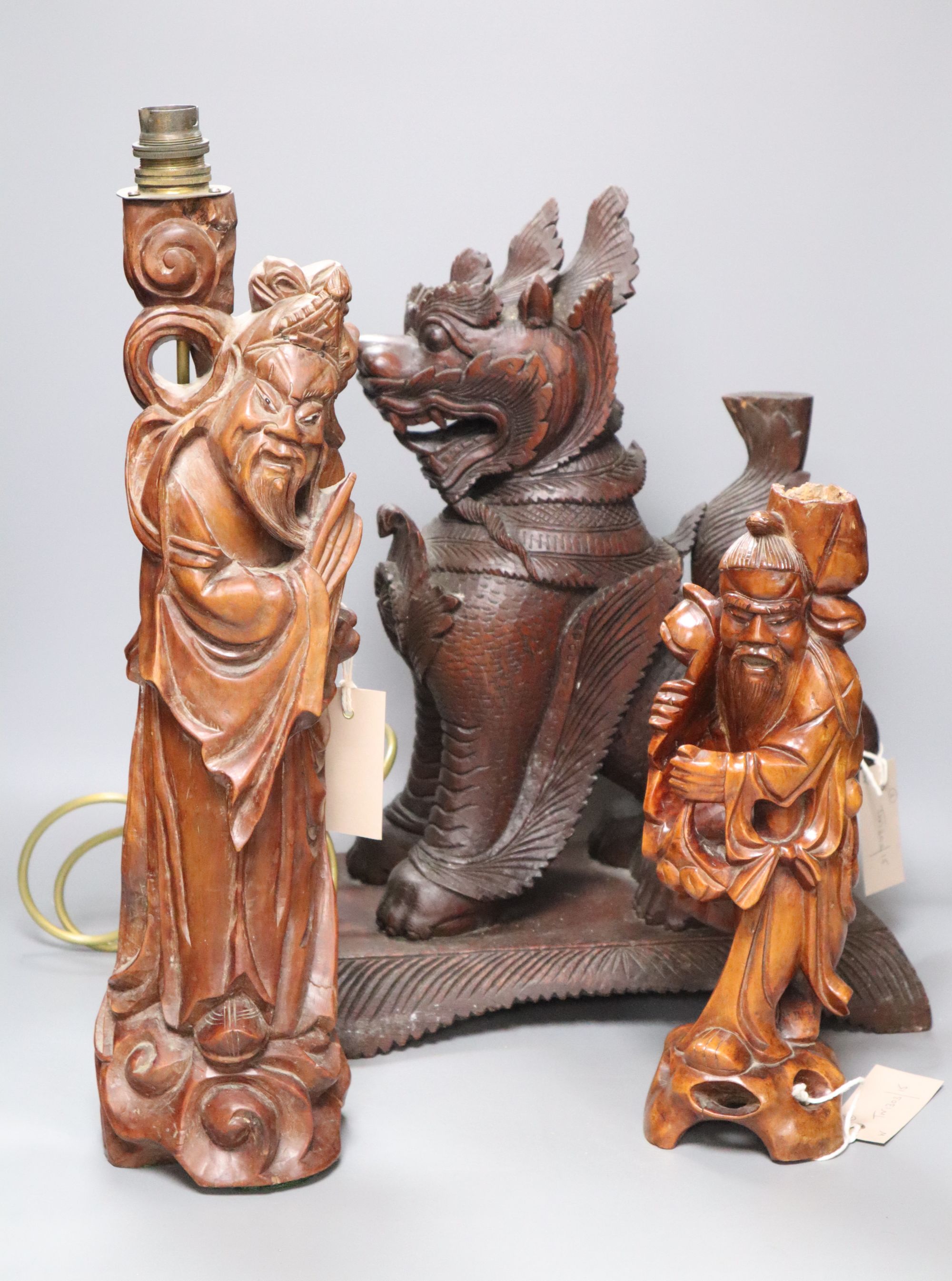 An Indonesian large carved wood model of a seated kylin, on plinth base and two Chinese rootwood carvings of elders, H approx 44cm (kyl